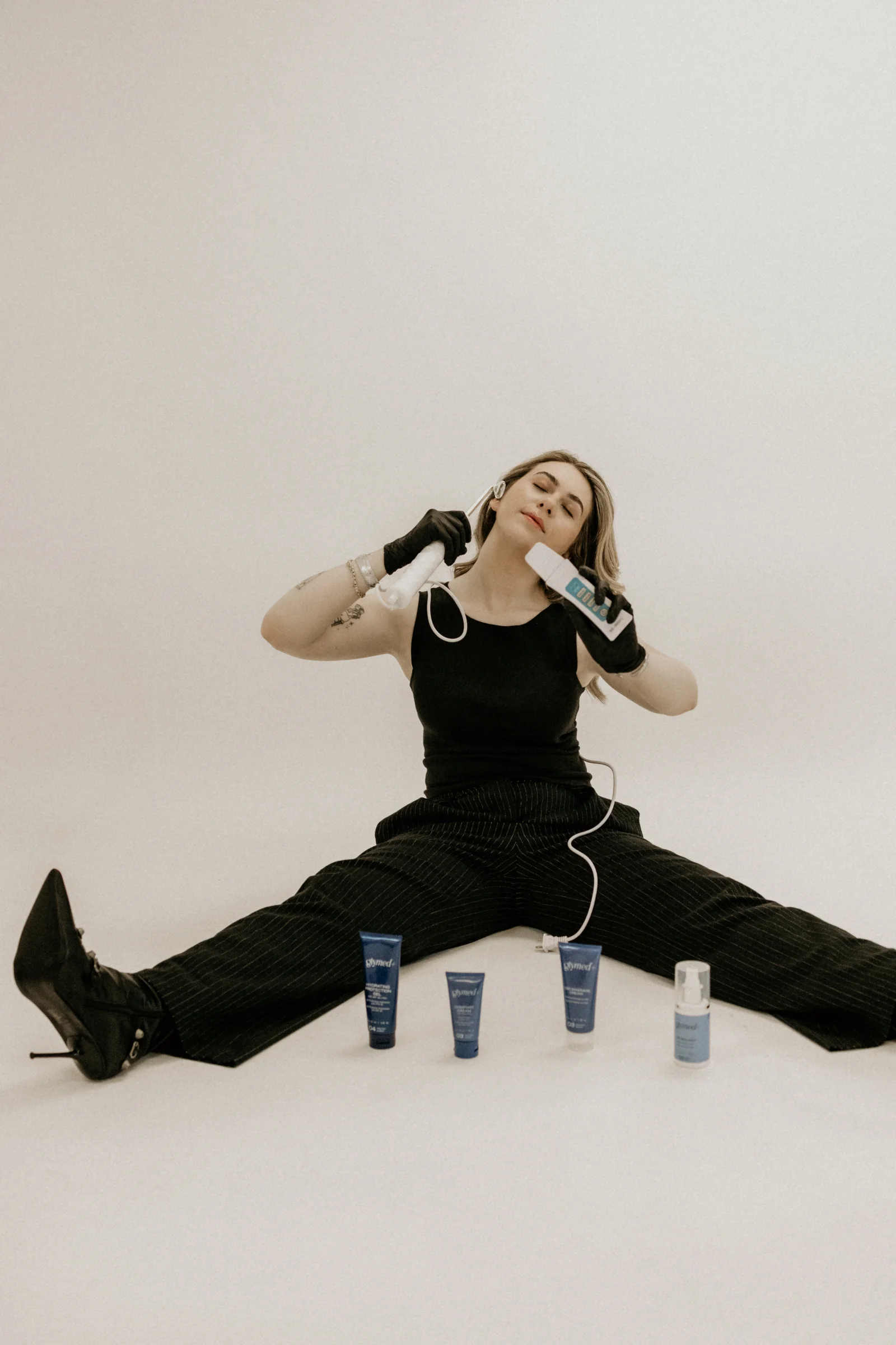 Emily of EmGlowSkin holding facial treatment tools and skincare products
